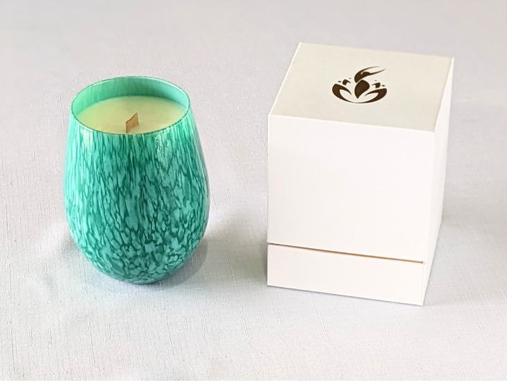 BathCalm's Coastal Caress Candle is set in a pretty turquoise jar, evocative of a calm tropical seas. BathCalm’s wooden wick candle is made from environmentally friendly Ecococowax. Each candle has a burn time of 60+ hours and comes with its own luxury white and gold branded box.