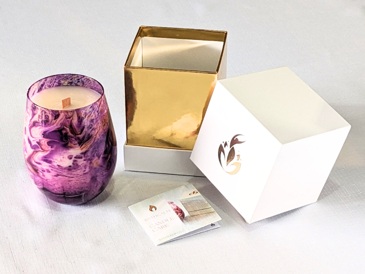 Set in a beautiful purple jar with swirls of mauve and purple, Cosmic Bliss features an exquisite blend of Cinnamon Nutmeg, Balsam, Frankincense, Patchouli and Sandalwood fragrance oils, with just a hint of citrus. With a wood wick set in Ecococwax, the Cosmic Bliss burn time is 60 plus hours. The Cosmic Bliss Candle comes with a sturdy white and gold branded box, adding a touch of luxury.